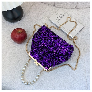 Detail der lila Pailletten-Abendtasche mit Goldkette und großem Perlenhandgriff
