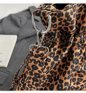 Close-up of leopard print canvas bag with silver D-ring and lobster clasp hardware