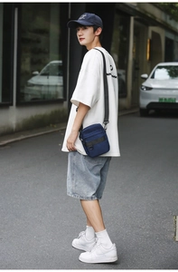 Detail view of durable navy nylon crossbody bag with functional D-ring and adjustable strap