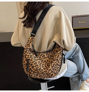Detailed back view of a trendy leopard print canvas crescent bag worn as a crossbody
