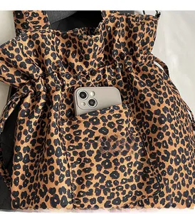 Detail of leopard print canvas bag front pocket showing storage for a smartphone
