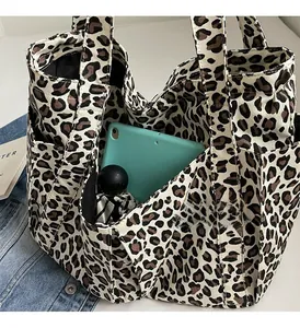 Dettaglio della borsa in tela leopardata con grande capacità per tablet e ombrello