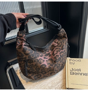Detail view of leopard print canvas hobo bag with adjustable black strap and zipper