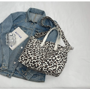 Close-up of leopard print canvas tote bag with adjustable shoulder strap and outer pocket