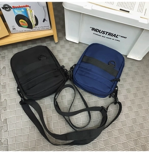 Detail view of tactical nylon crossbody bags in black and navy with adjustable straps