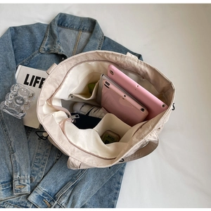 Detail view of large cream tote bag showing internal storage capacity and pockets