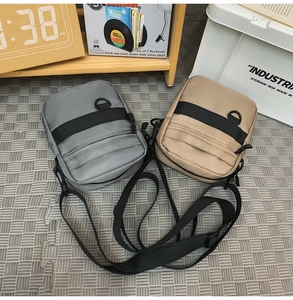 Detail view of khaki and grey waterproof nylon messenger bags with multi-layer zipper storage