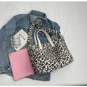 Detail view of canvas leopard print tote bag with stylish wide shoulder strap and side pocket