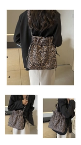 Detail of leopard print canvas bucket bag showing drawstring closure and metal hook