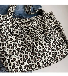 Dettaglio ravvicinato della borsa tote leopardata in tela con tasca laterale e denim