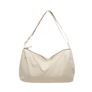 Detail van de crème nylon crossbodytas met fijne rimpeltextuur en een ritssluiting
