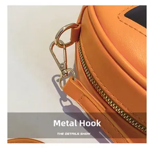 Macro shot of durable golden hardware hook and zipper detail on orange pumpkin bag