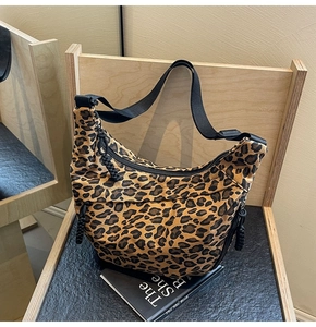 Detail of hobo bag with leopard print canvas, adjustable strap and front zipper pocket