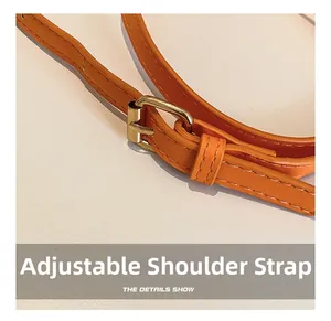 Detail of adjustable orange PU leather shoulder strap with golden metal buckle and stitching