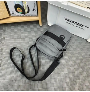 Detail view of dark grey nylon messenger bag with metal D-ring and adjustable strap