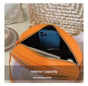 Internal capacity of the orange pumpkin bag showing compartments for phone and cosmetics