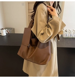 Gros plan d'un cabas en cuir marron texturé avec une petite pochette latérale assortie