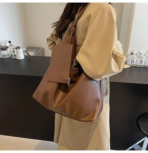 Détail d'un grand sac cabas marron en cuir avec texture et pochette zippée suspendue