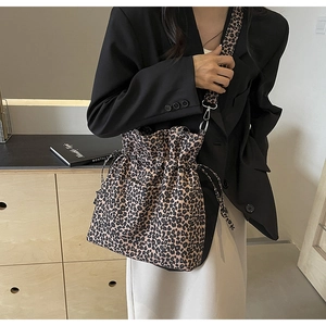 Detail of leopard print canvas shoulder bag showing drawstring closure and wide strap