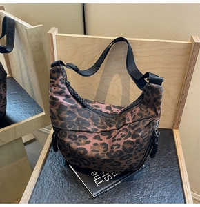 Detail of the side zipper pocket and leopard print canvas on the hobo shoulder bag