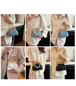Detail of vintage floral denim handbag with wooden clasp and pearl strap on model