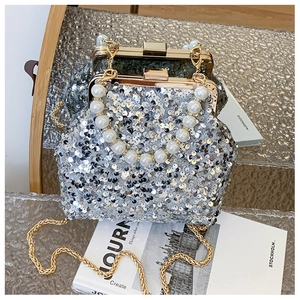Detail der silbernen Pailletten-Muschel-Tasche mit Perlengriff und goldener Kette