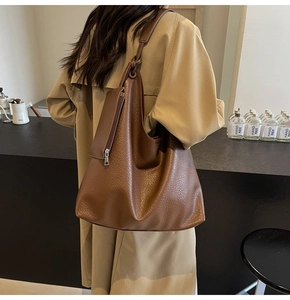 Détail d'un sac Hobo en cuir marron montrant la finition texturée et la petite pochette