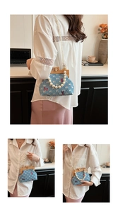 Detail of denim handbag featuring butterfly embroidery and pearl bead shoulder strap