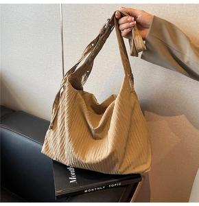 Detail der khakifarbene Cord-Hobo-Tasche mit verstellbarer silberner Metallschnalle und Textur