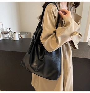 Détail du sac cabas noir en cuir texturé litchi avec une poche zippée latérale pratique