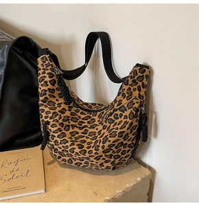 Close-up of leopard print canvas hobo bag with adjustable wide black strap