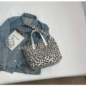 Detail view of leopard print canvas tote bag with adjustable crossbody strap and handles