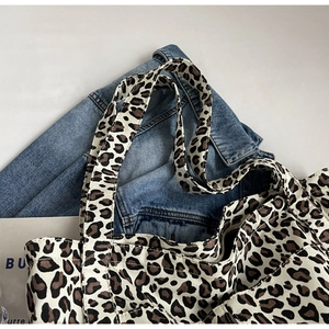 Dettaglio della borsa tote in tela leopardata sopra una giacca di jeans blu denim
