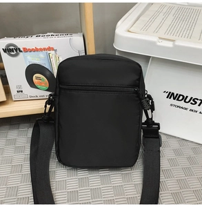 Close-up of waterproof black nylon crossbody bag showing durable texture and adjustable strap