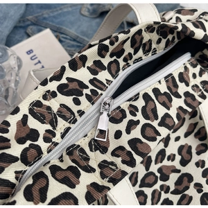Detailed close-up of the high-quality silver metal zipper on leopard print canvas bag