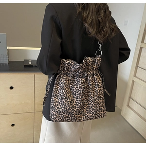 Detail of leopard print canvas shoulder bag with drawstring closure and square front pocket