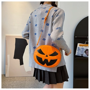 Detail of pumpkin crossbody bag with leather face stitching worn by a model