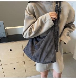Detail der dunkelgrauen Cord-Einkaufstasche mit silbernen Ösen und Multi-Gurt-Design