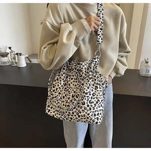 Detail of leopard print canvas tote bag with drawstring closure and wide shoulder strap