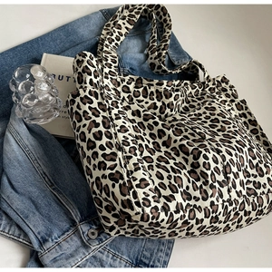 Dettaglio della trama leopardata della borsa tote in tela e della pratica tasca laterale