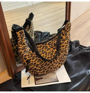 Detail showing leopard print canvas hobo bag with adjustable wide black shoulder strap
