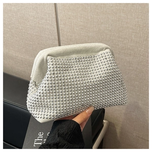 Close-up of white suede shell bag with glittering silver rhinestones for evening events