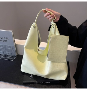 Détail du sac Hobo jaune crème avec texture litchi et mini pochette assortie incluse