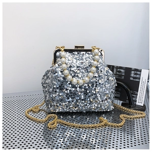 Detailansicht einer silbernen Pailletten-Clutch mit Perlengriff und goldener Kette
