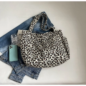 Dettaglio della borsa tote grande in tela leopardata con tasche laterali e texture