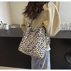 Detail of large leopard print canvas tote bag with drawstring in a lifestyle setting