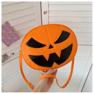 Detail of pumpkin-shaped crossbody bag with black jack-o'-lantern face and adjustable strap