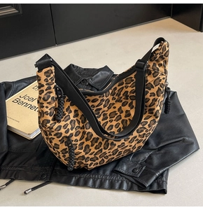 Detailed macro view of leopard print canvas crescent bag with black adjustable strap