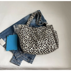 Vista dettagliata della borsa tote grande in tela leopardata con tasche laterali funzionali