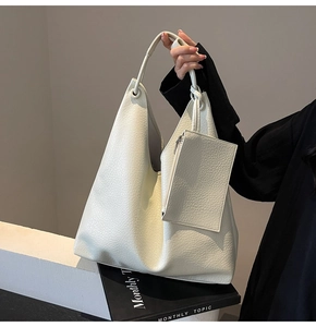 Gros plan du sac cabas en cuir grainé blanc avec sa pochette assortie élégante
